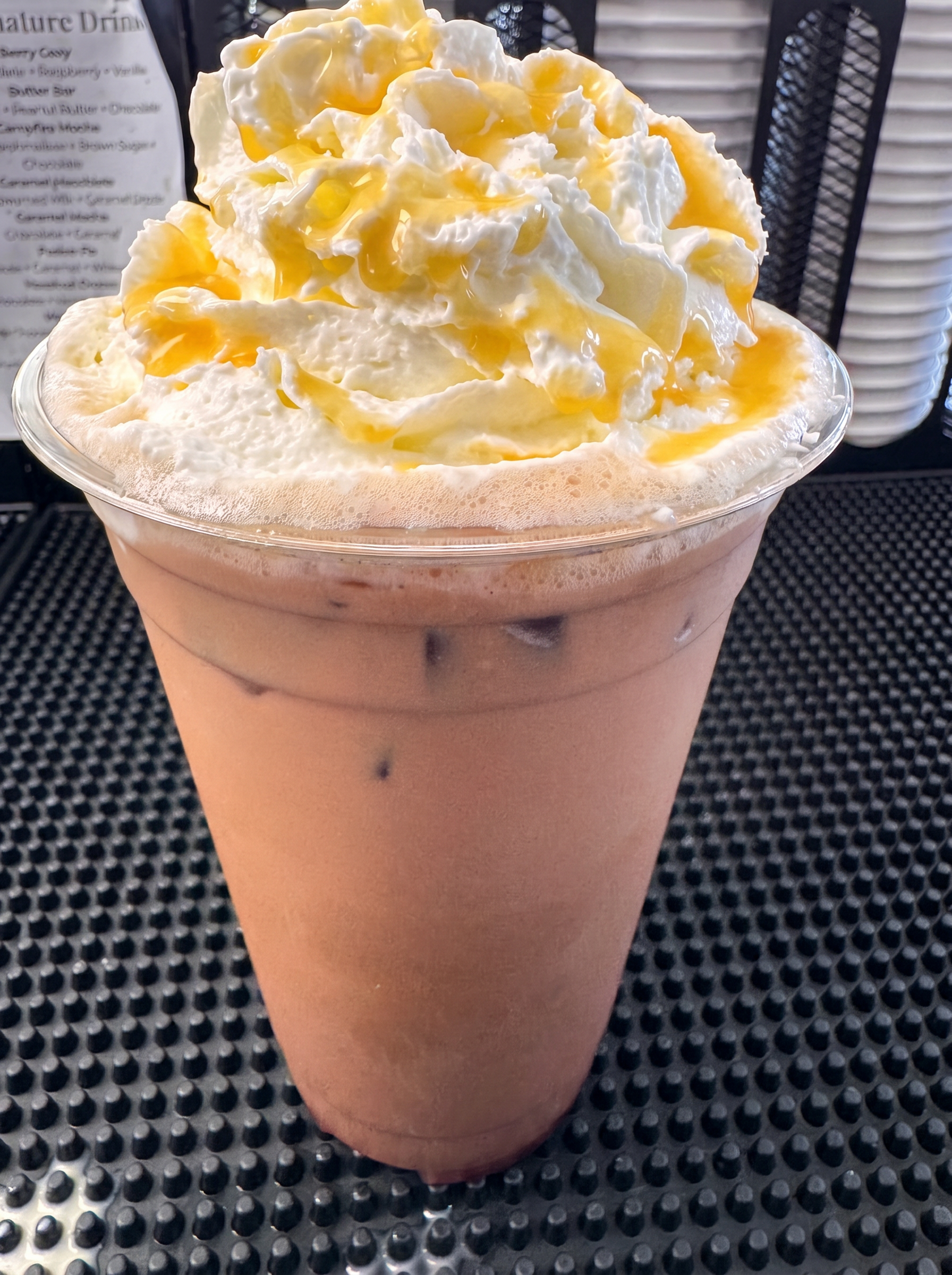 Iced caramel drink topped with whipped cream and caramel drizzle